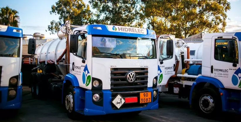 A foto mostra três caminhões da Hidrelec Saneamento Ambiental