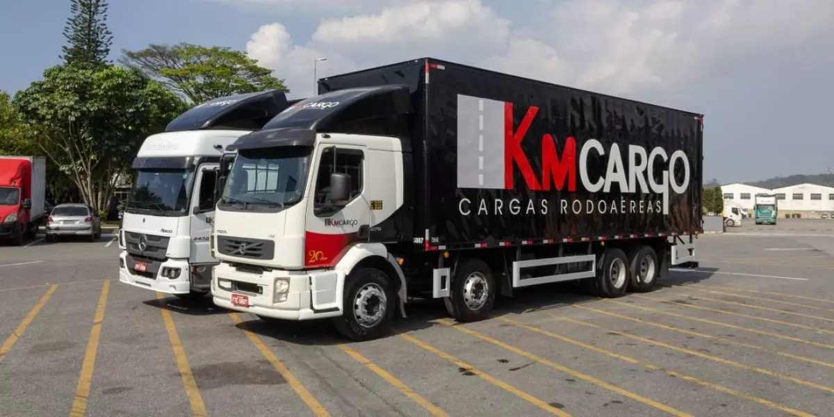 A foto mostra dois caminhões da KM Cargo