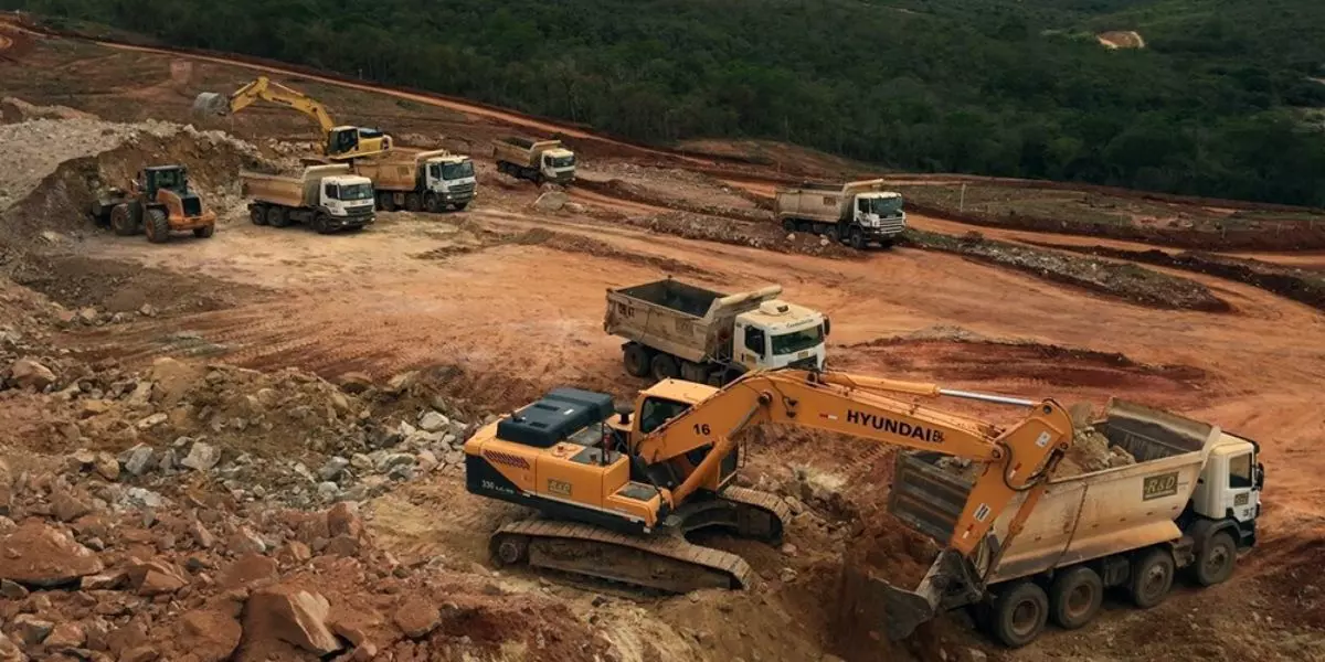 A foto mostra uma operação de Mineração com caminhões basculante da R&D Mineração