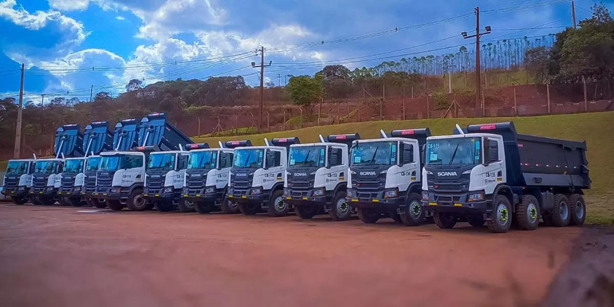 A foto mostra uma frota de caminhões da Herculano Mineração