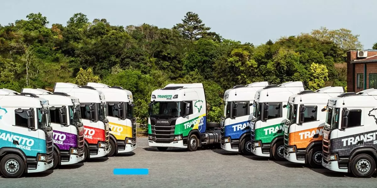 A foto mostra uma frota de caminhões da Transito Brasil