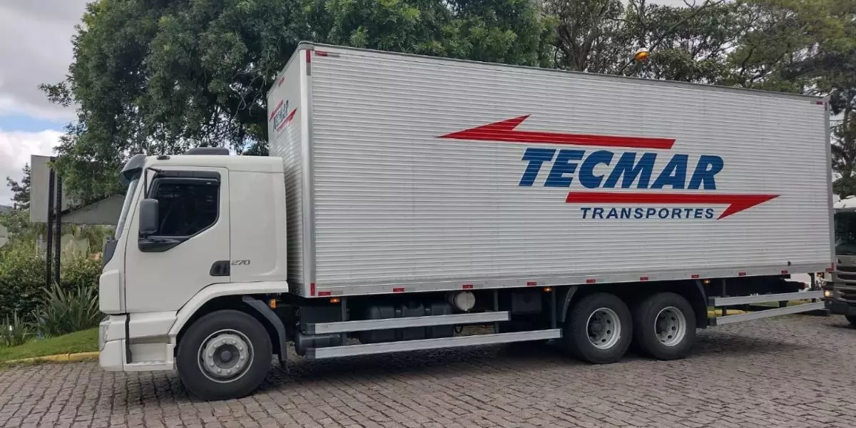 A foto mostra um caminhão da Tecmar Transportes