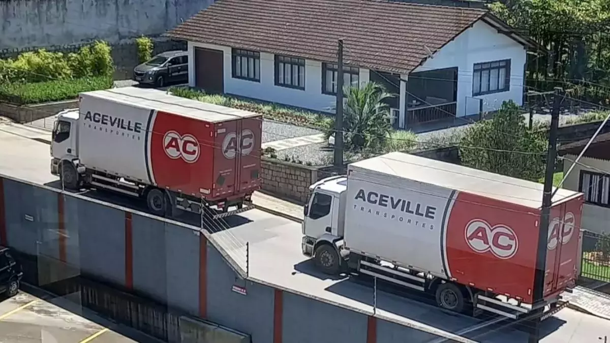 A foto mostra dois caminhões da Aceville Transportes