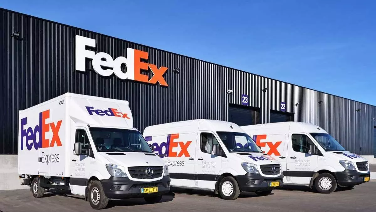 A foto mostra uma frota de caminhões e vans da FedEx