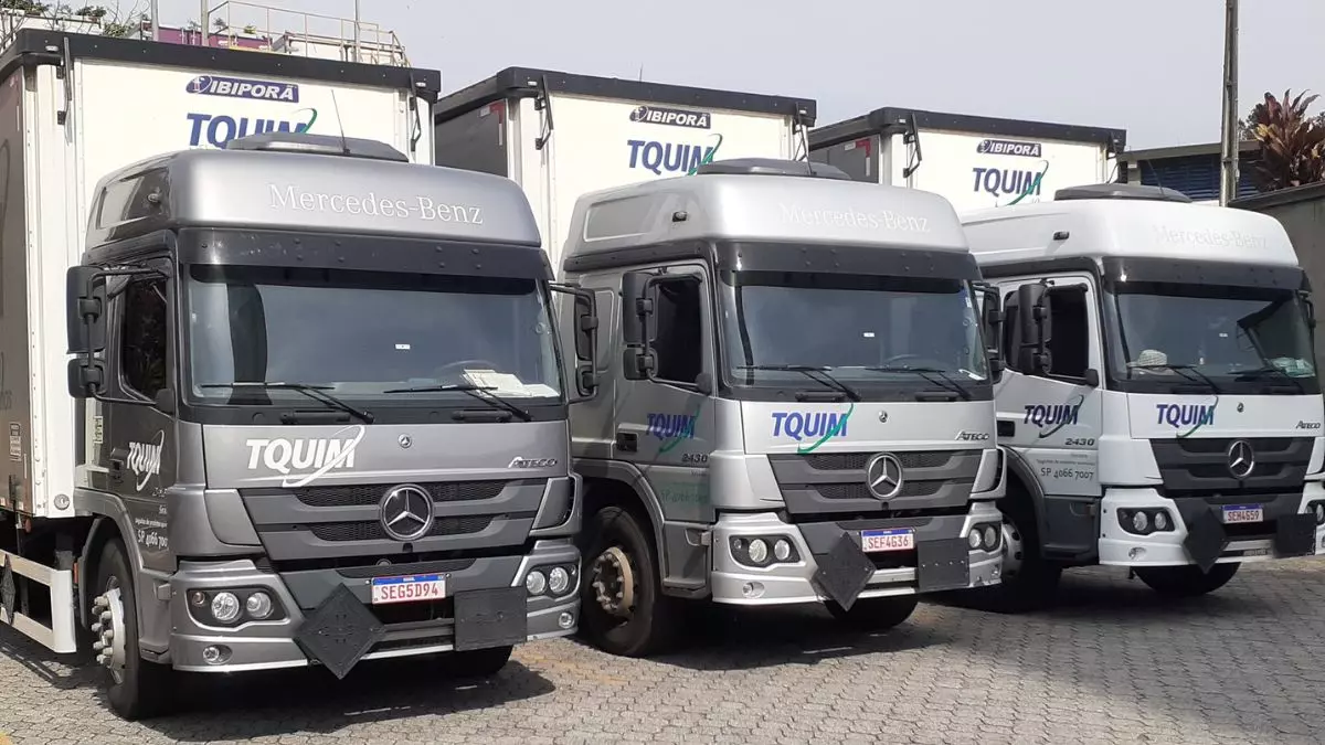 A foto mostra uma frota de caminhões da TQUIM Transportes