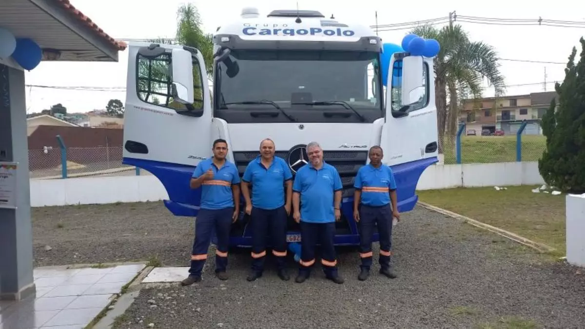 A foto mostra um caminhão e 4 motoristas do Grupo Cargo Polo