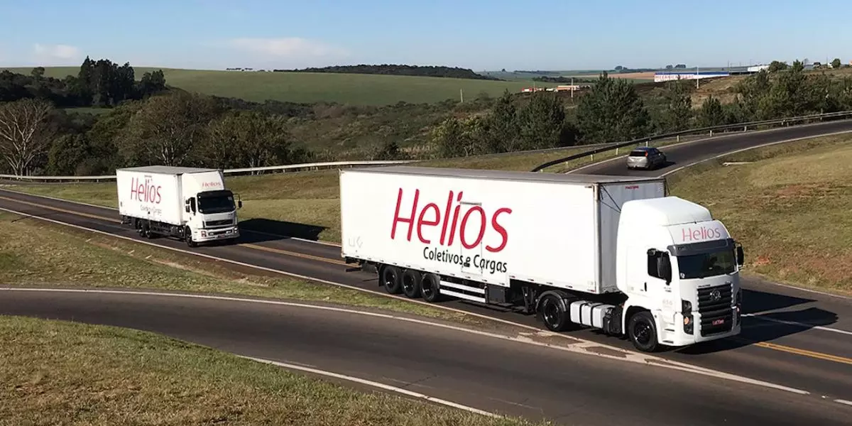 A foto mostra dois caminhões da Helios Cargas