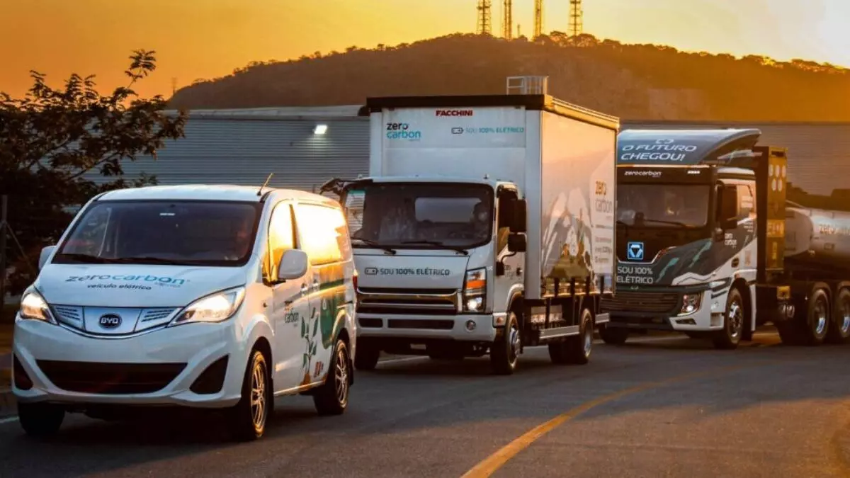 A foto mostra uma frota de veículos da Zero Carbon Logistics, contendo, carro, caminhão e carreta