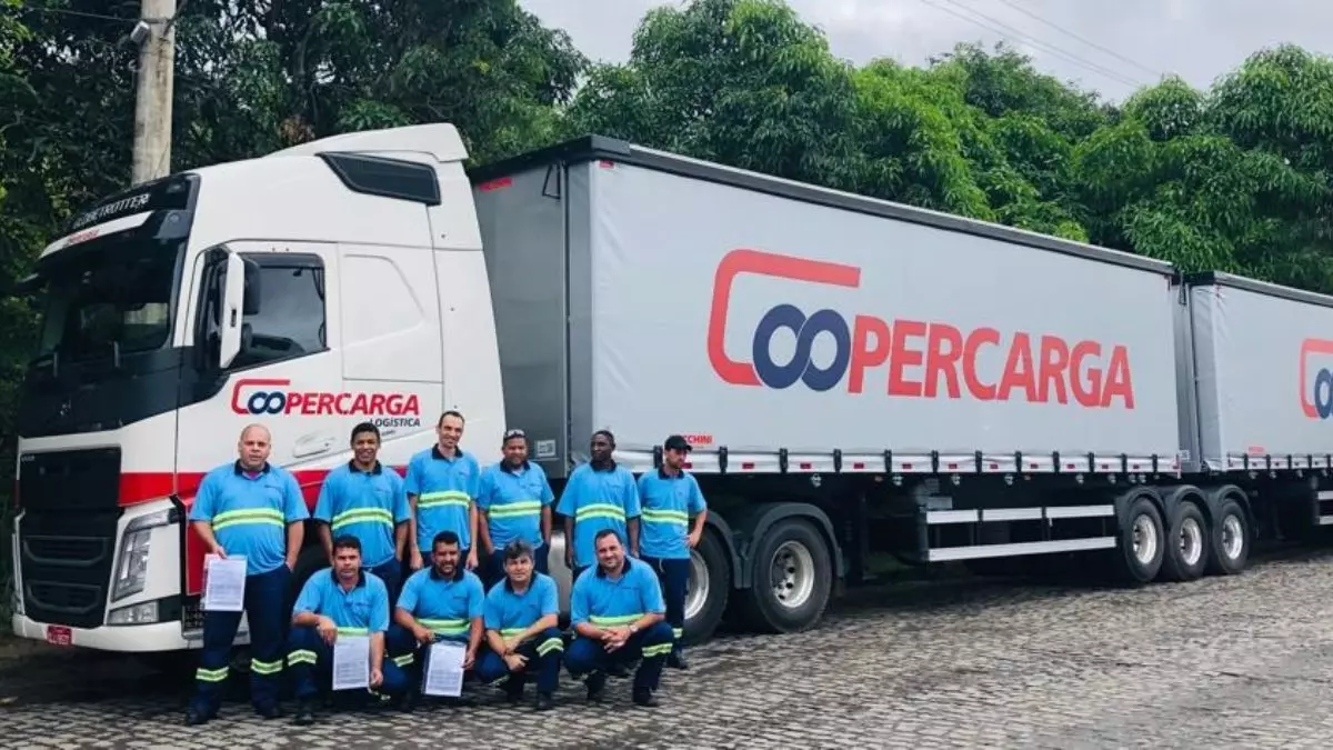 A foto mostra uma carreta da Coopercarga e 10 motoristas