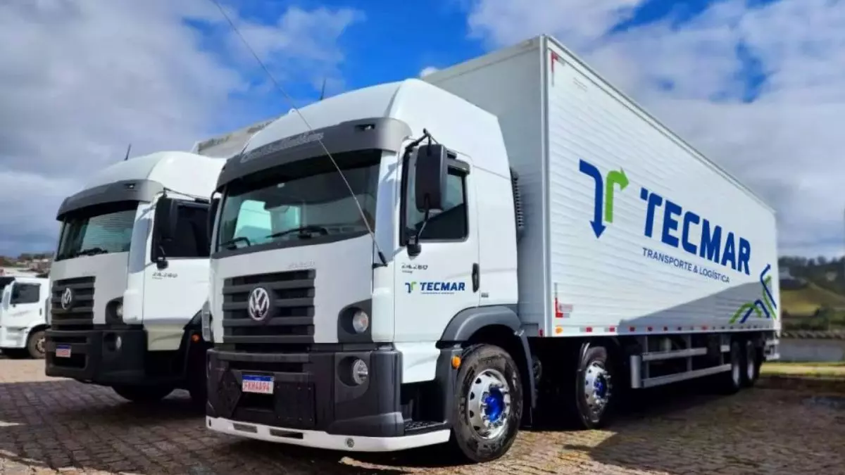 A foto mostra dois caminhões da Tecmar Transportes