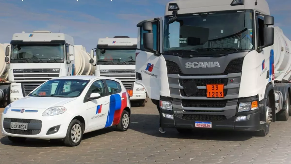 A foto mostra uma frota de veículo e caminhões da AJ Transportes